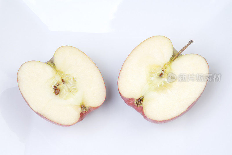 在白色盘子上切成两半的苹果