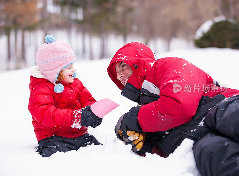 女孩和爸爸在雪中玩耍