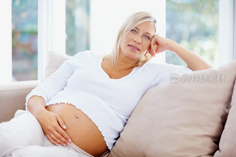 中年孕妇在家抱着肚子