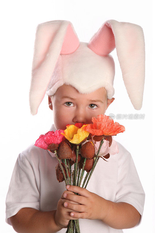 男孩的肖像打扮成复活节兔子拿着花沉思
