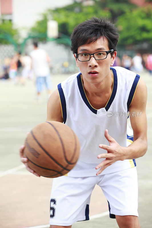 年轻的亚洲大学生打篮球