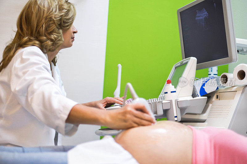妇科医生对孕妇进行超声波检查。