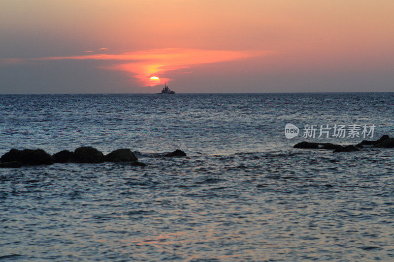 海滩日落与过往的船