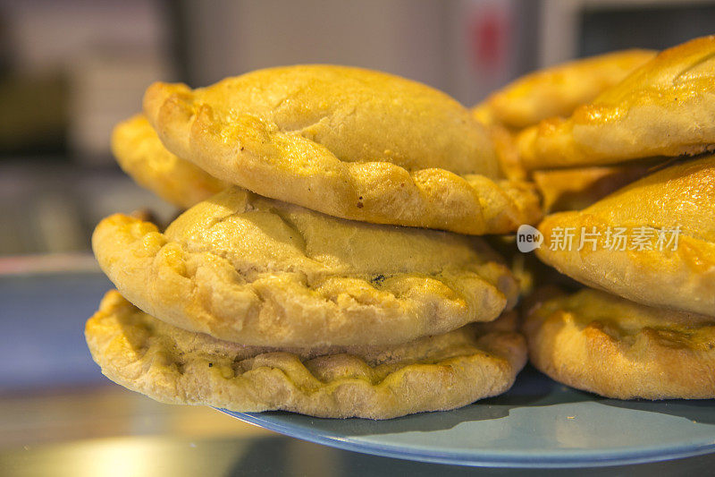 西班牙巴塞罗那的boqueria露天市场上新鲜出炉的肉馅卷饼