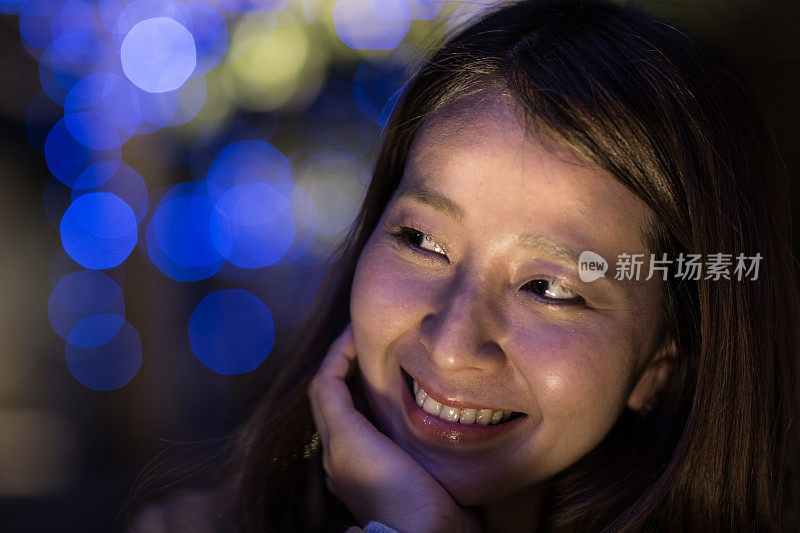 一个女人晚上在城市里微笑的肖像