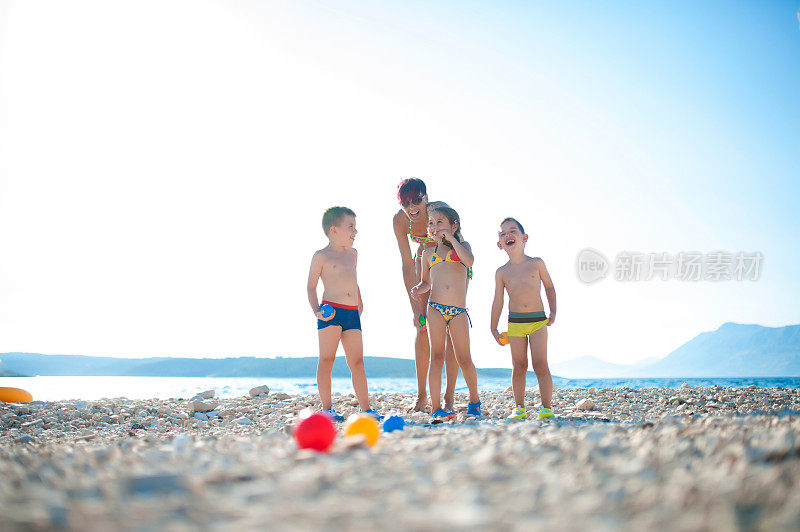 妈妈和孩子们在海滩上玩地瓜