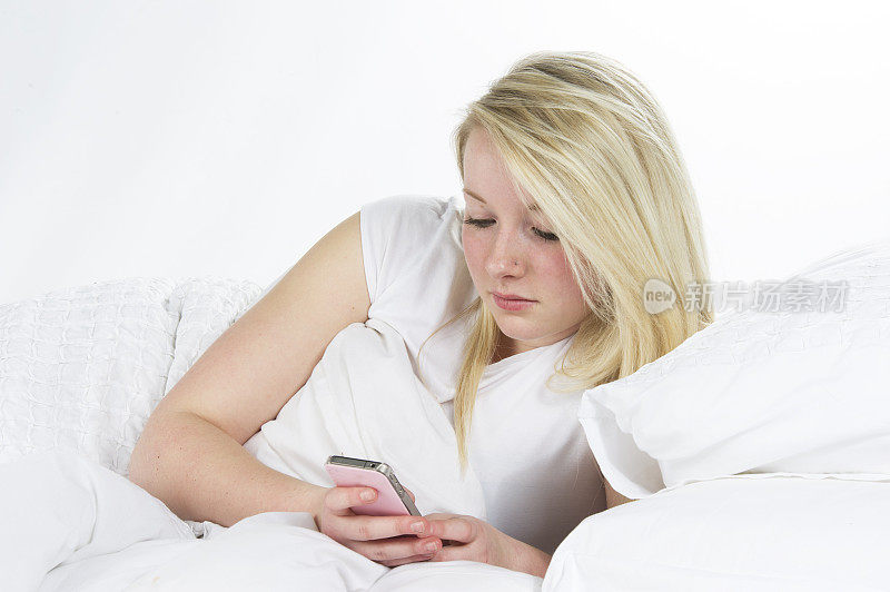 青少年在床上玩手机