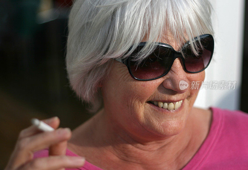 一个快乐的老女人吸烟的肖像
