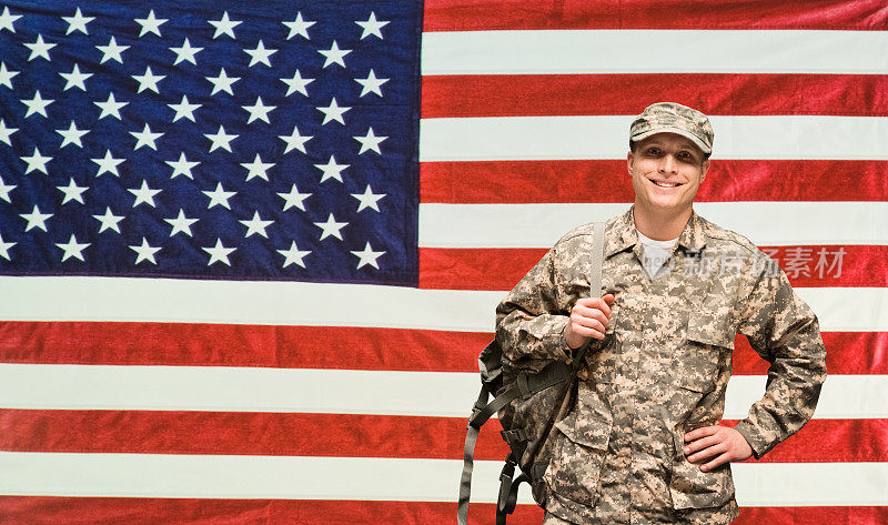在美国国旗前微笑的士兵