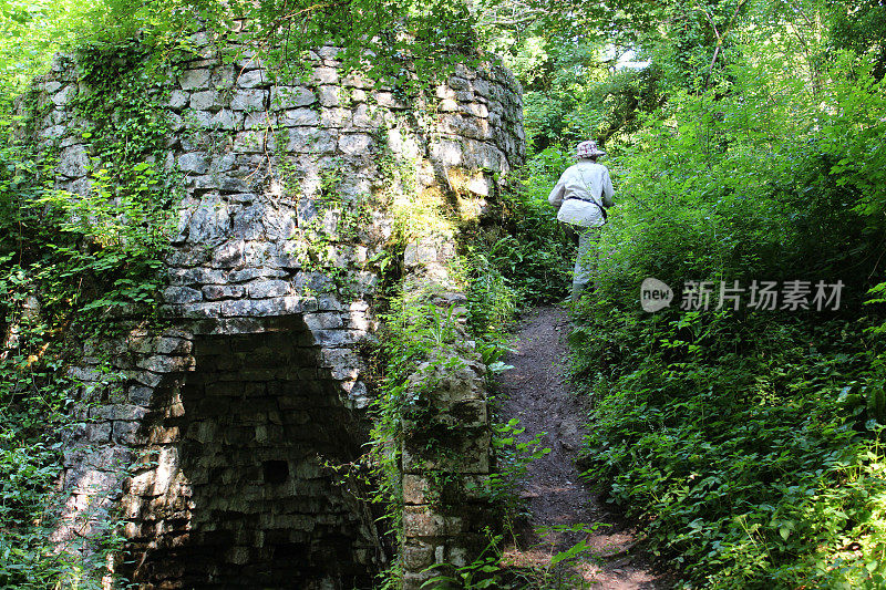森林中古老的石灰窑，妇女攀登的形象