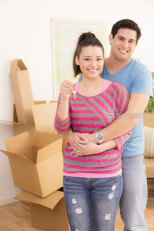 搬家，家园:拉丁裔夫妇炫耀钥匙。新房子。