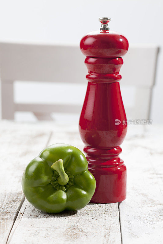 青椒，红椒粉碎机放在白色木桌上