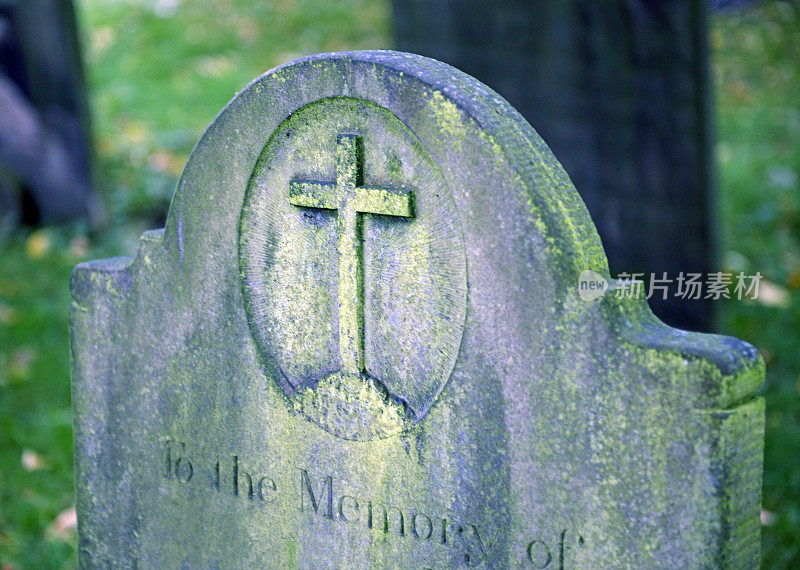 古老的长满青苔的墓碑上有十字架和字
