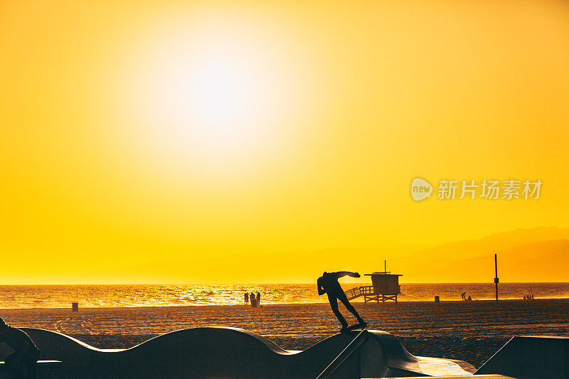 滑板在日落的威尼斯海滩，加州，美国