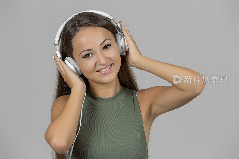微笑的女孩戴着耳机听音乐