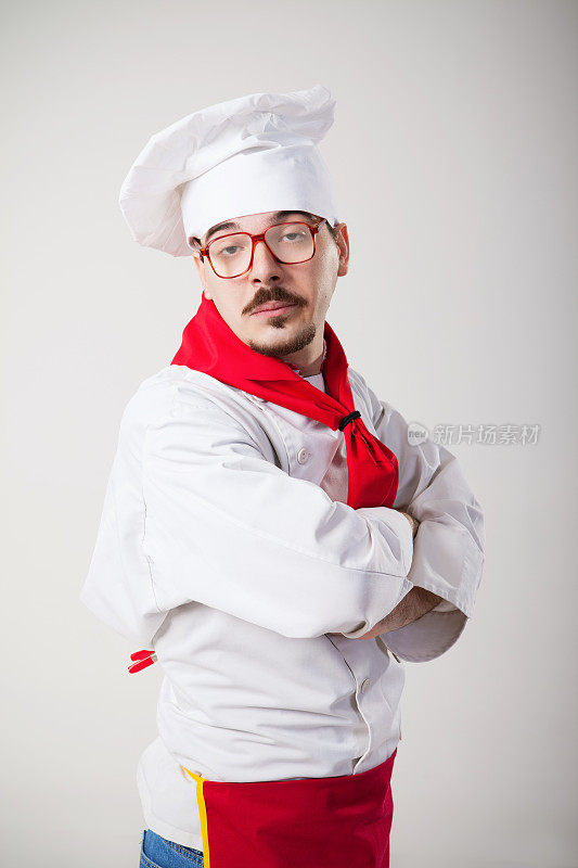 无聊的书呆子厨师，戴着眼镜，双臂交叉摆姿势
