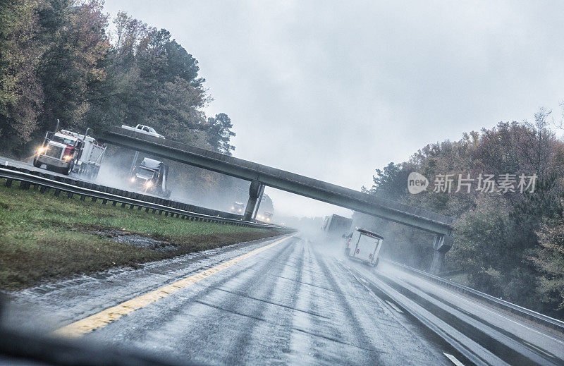 在暴雨期间，高速公路上行驶着商用卡车