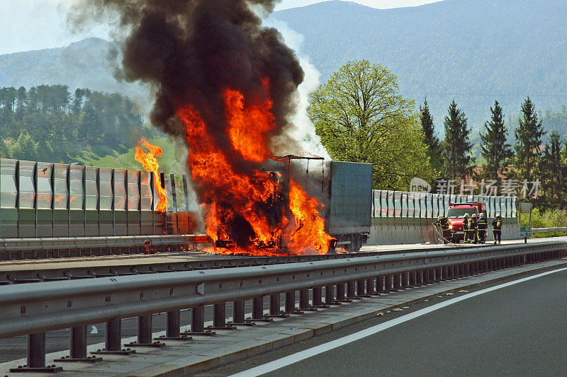 高速公路上的卡车着火了，消防员正在靠近