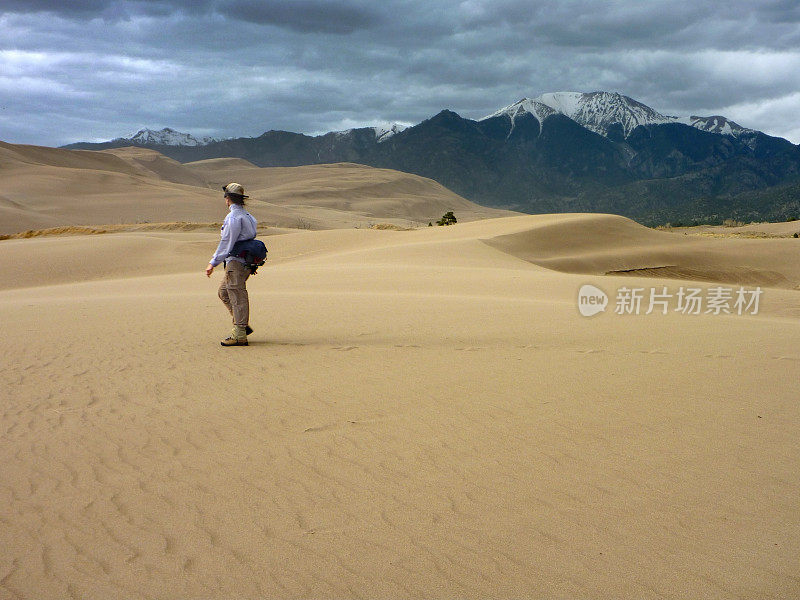 女人走过暴风雨的大沙丘国家公园科罗拉多