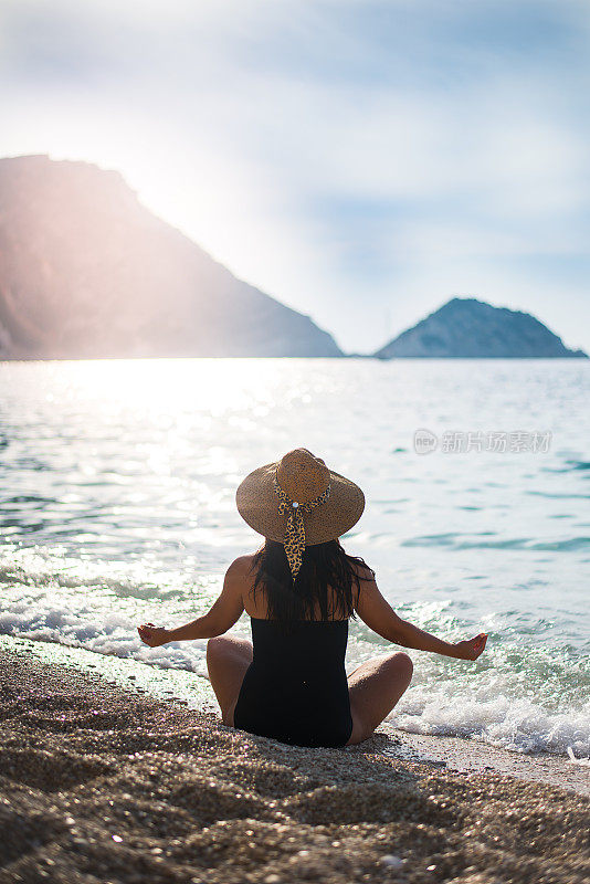 沉思的女孩在大海和夕阳的背景