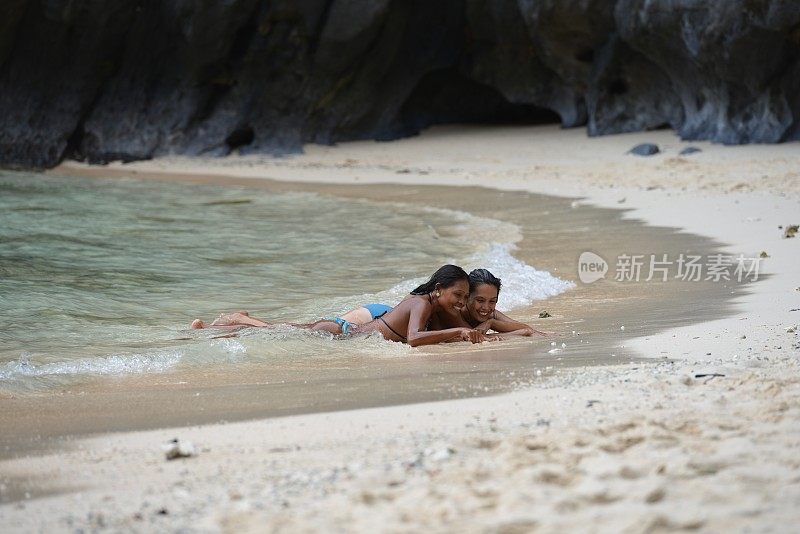 两个美丽的女人躺在异国情调的海滩上