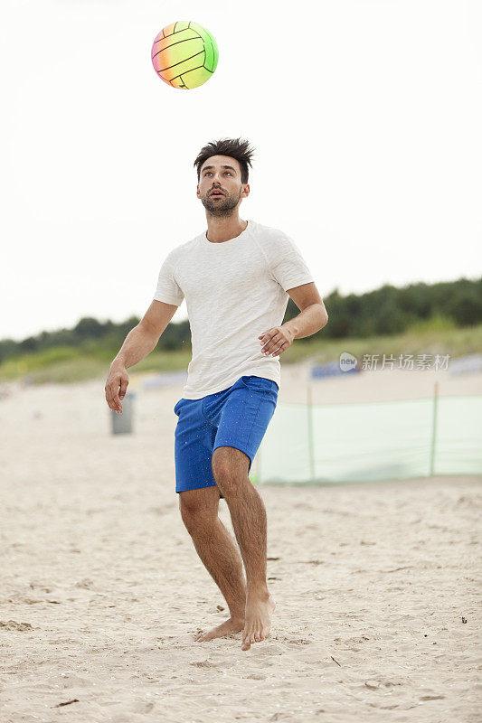 男人在沙滩上踢球