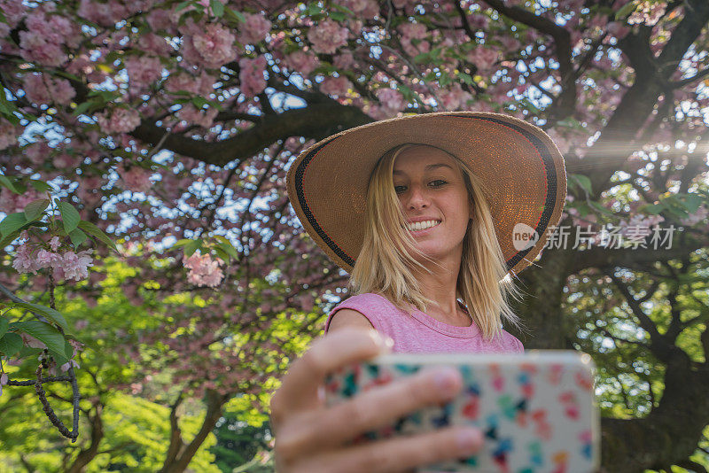 东京，年轻女子与樱花树的自拍