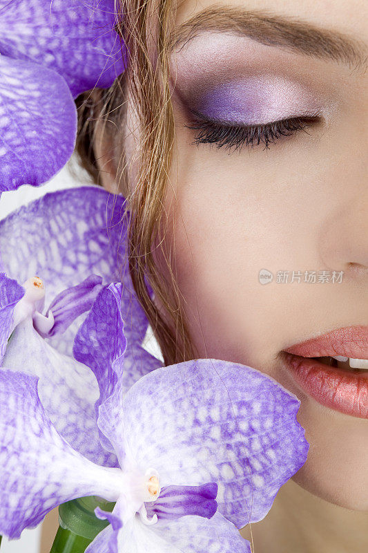 特写的美丽女性的脸与紫罗兰兰花。XXXL