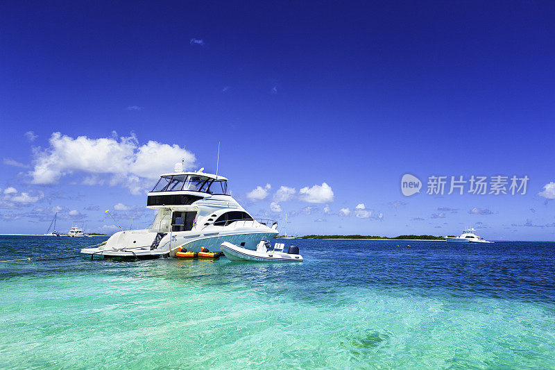 一艘豪华游艇停泊在热带岛屿的绿松石海滩上