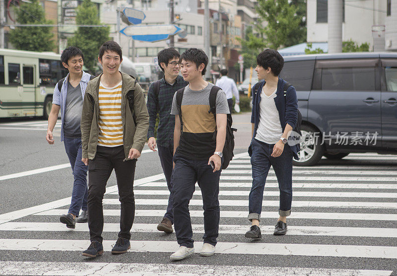 在日本京都，日本学生和同学一起过红绿灯