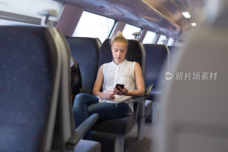 女子在火车上使用手机。