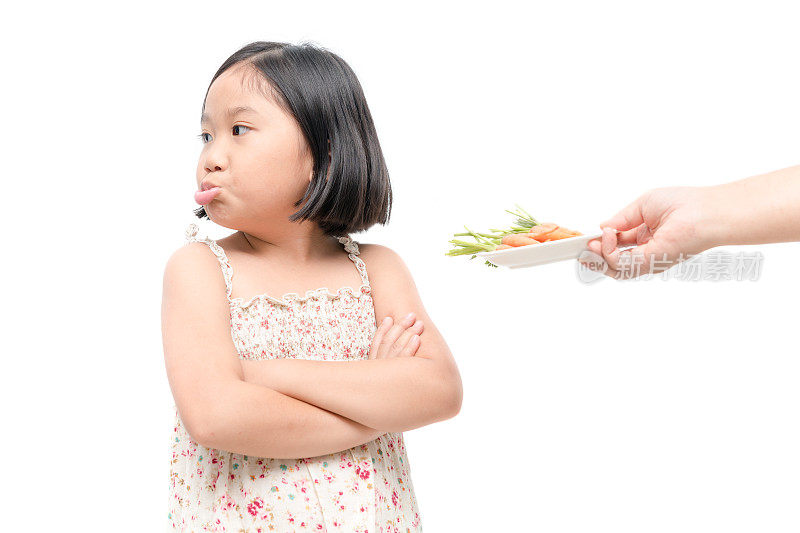 亚洲女童与表达厌恶的蔬菜孤立在白色背景