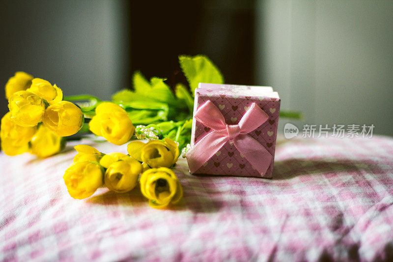 粉色背景上的礼盒和鲜花