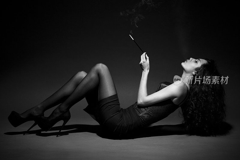 女人在黑暗中吸烟。空间的文本。BW形象