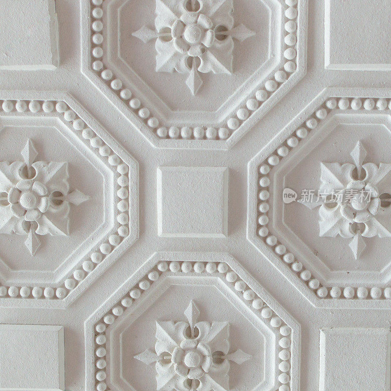 白色几何装饰图案的天花板为背景，正方形