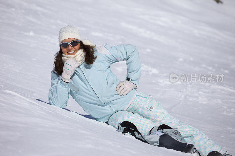 女滑雪者享受阳光，日光浴，躺在阳光明媚的滑雪胜地白云石在意大利业余冬季运动