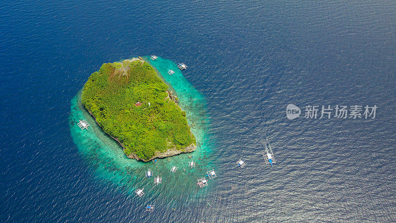 在菲律宾宿务岛Oslob附近的Sumilon岛海滩上，游客在美丽清澈的海水中游泳的沙滩鸟瞰图。-增强颜色处理。