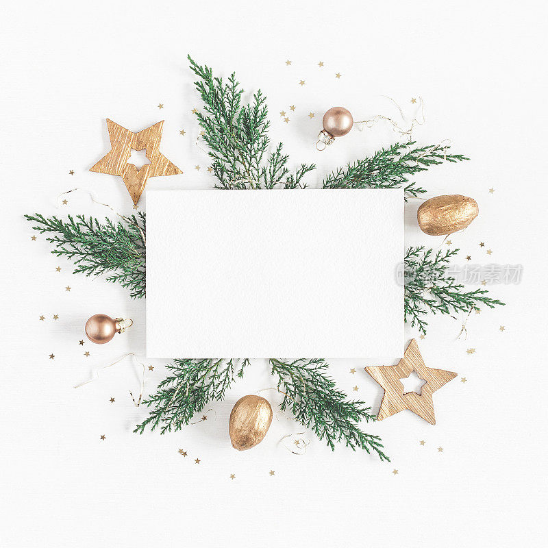 纸空白，圣诞树的树枝，金色的装饰品。平躺