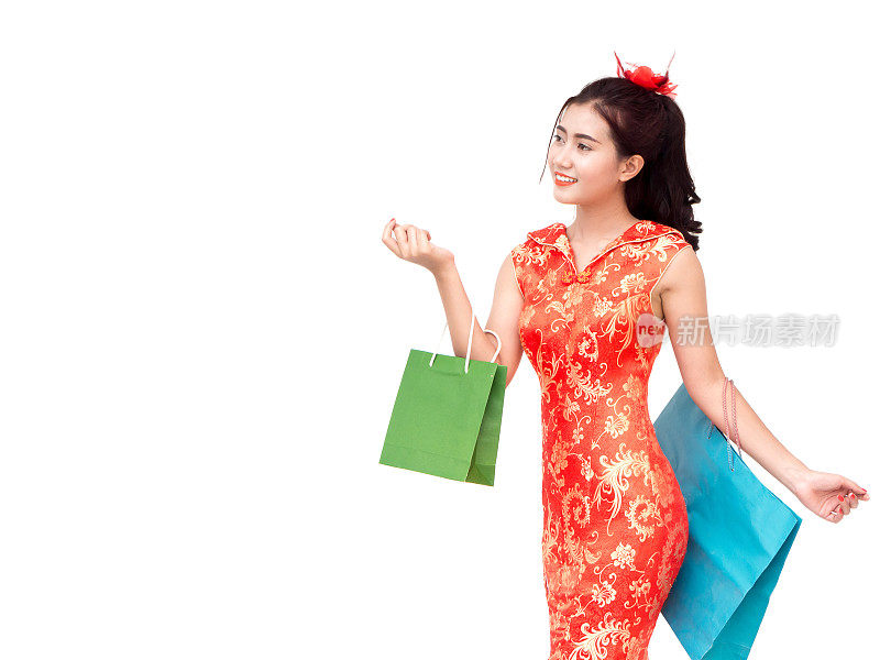 农历新年亚洲女性概念，孤立的亚洲女性穿着红色连衣裙(旗袍)拿着购物袋