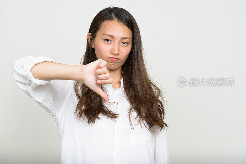 年轻美丽的亚洲女人穿着白色衬衫对抗白色背景