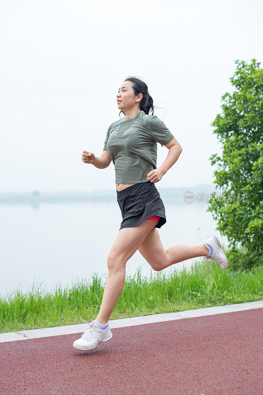 在加拿大湖滨路上慢跑的女性