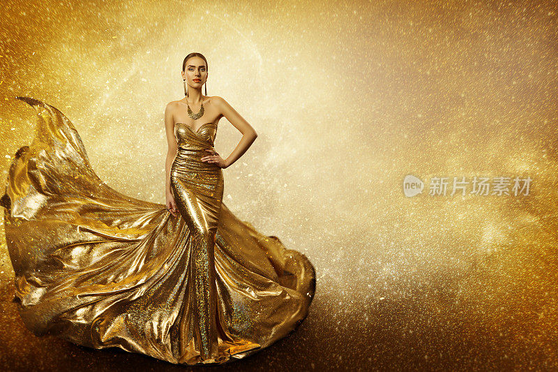 金色的时尚模特，优雅的女人飞翔的金色连衣裙，挥舞着闪闪发光的长袍面料