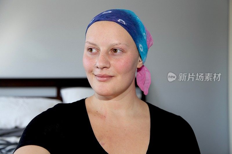 年轻的癌症患者戴着头巾微笑着