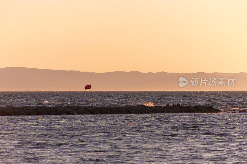 在土耳其巴利克希尔的阿瓦利克海滩，在日落时的夏季城镇海岸