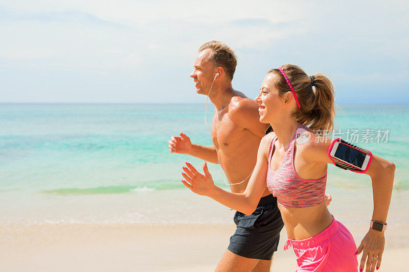 情侣在沙滩上慢跑时使用可穿戴设备