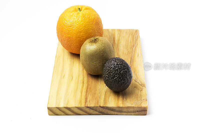 木板上放着橘子，猕猴桃和鳄梨