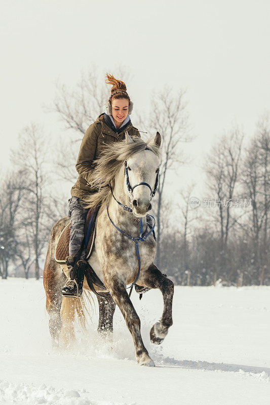 一个女人在雪地里骑马