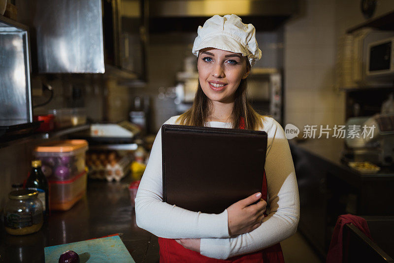 在餐馆工作的年轻女子，手里拿着菜单