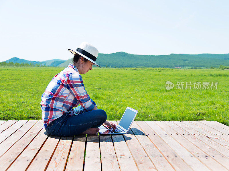 年轻女子在户外使用笔记本电脑