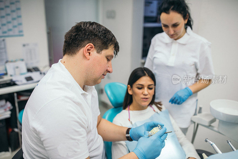 牙科医生向女病人展示牙科修复术